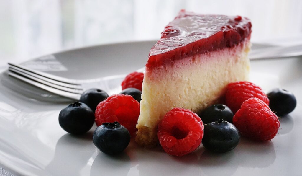 Une part de cheesecake tentante garnie de fruits rouges, parfaite pour les amateurs de dessert.