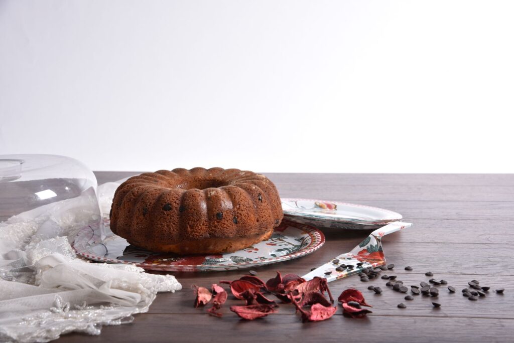 Gâteau Bundt fraîchement cuit avec des pépites de chocolat sur une assiette décorative, parfait pour les desserts.