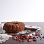 Gâteau Bundt fraîchement cuit avec des pépites de chocolat sur une assiette décorative, parfait pour les desserts.