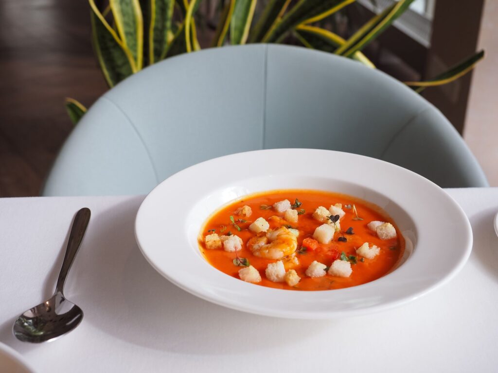 Élégant bol de soupe aux crevettes garni de croutons, parfait pour une cuisine gastronomique et la photographie culinaire.
