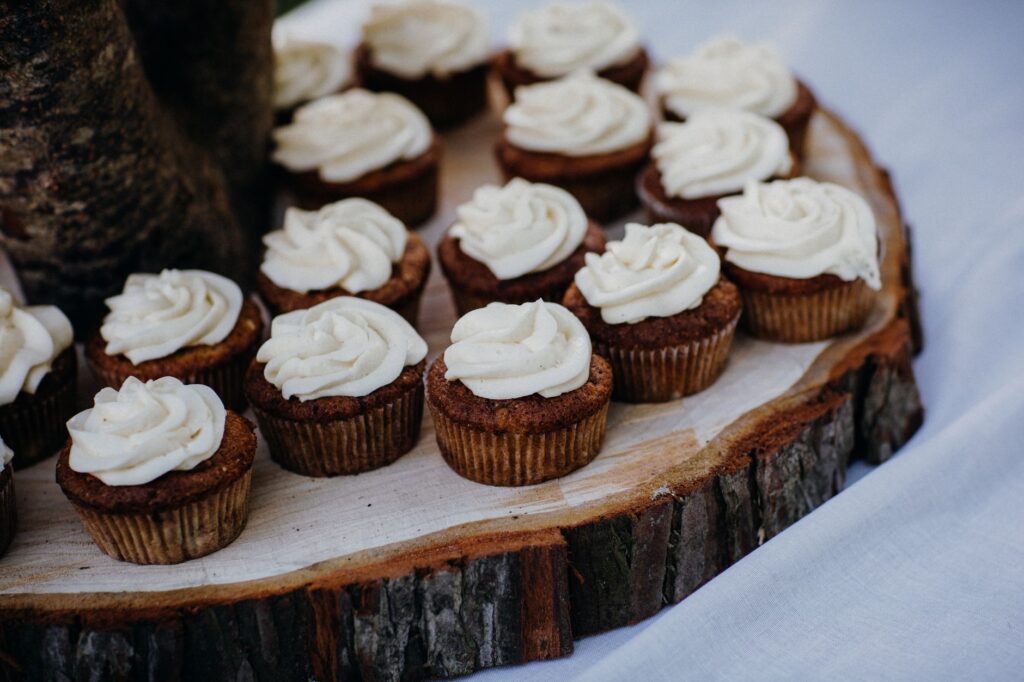 Plateau en bois présentant des cupcakes au chocolat avec un glaçage à la vanille, parfait pour les amateurs de dessert.