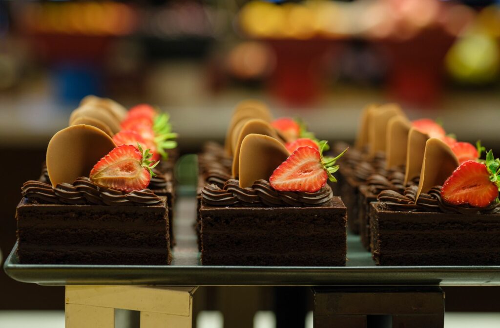 Des tranches de gâteau au chocolat irrésistibles ornées de fraîches fraises et de ronds au chocolat, parfaites pour les amateurs de dessert.