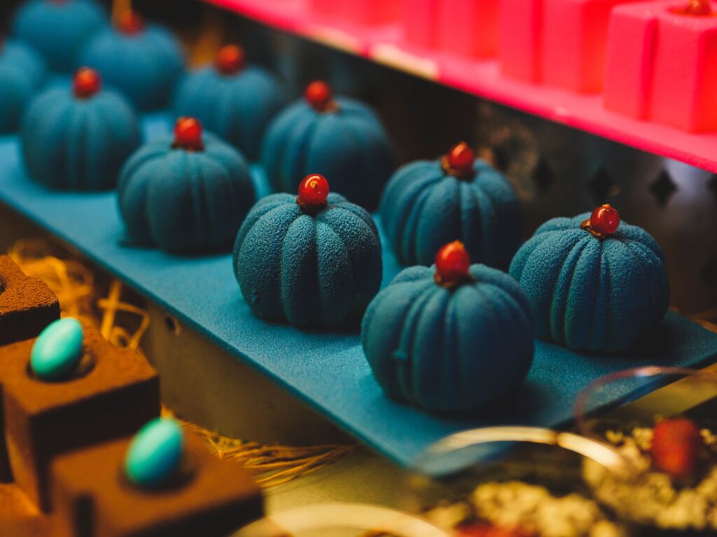 Gros plan sur des desserts en velours bleu élégamment présentés dans un cadre de boulangerie.