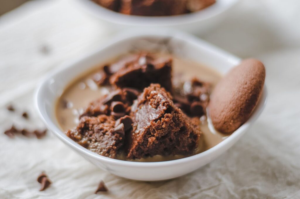Gros plan sur un dessert au chocolat riche servi dans un bol en céramique blanche avec une touche d'indulgence.