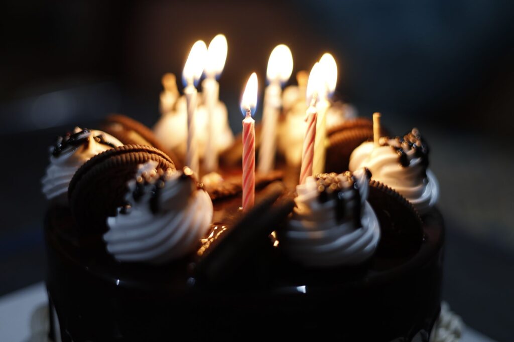 Gros plan sur un gâteau au chocolat avec des bougies et des biscuits, parfait pour les célébrations.
