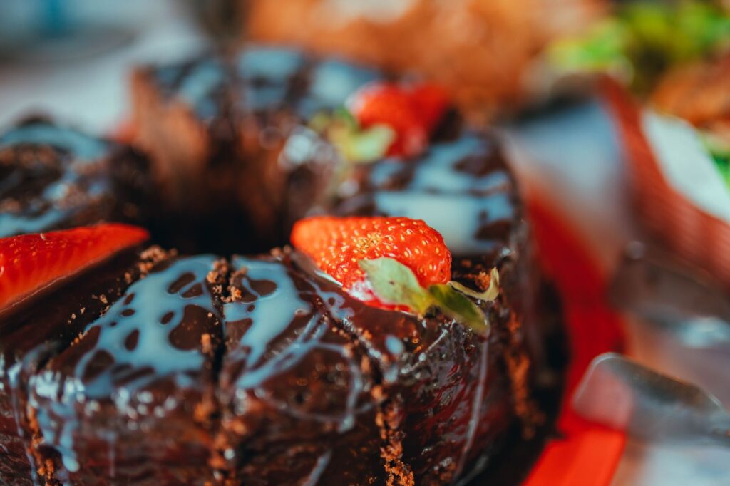 Savourez un riche gâteau au chocolat surmonté de fraises fraîches et de glaçage.