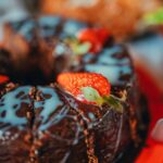 Savourez un riche gâteau au chocolat surmonté de fraises fraîches et de glaçage.