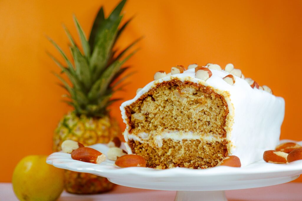 Gros plan d'un gâteau aux ananas et aux amandes sur un support, parfait pour les amateurs de desserts.