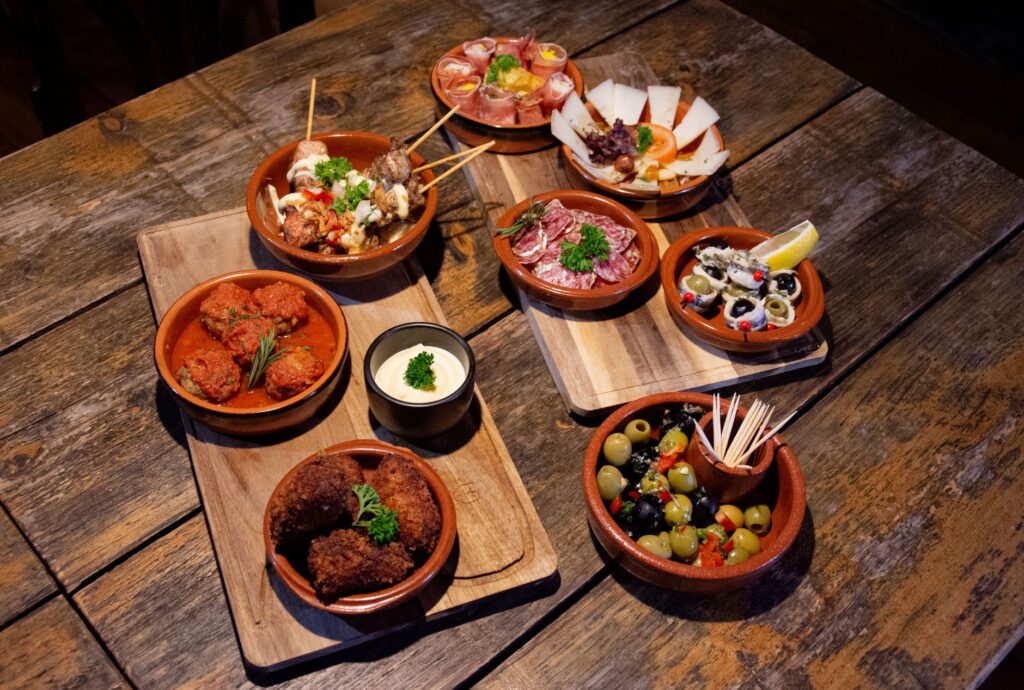 Un assortiment délicieux de tapas traditionnelles servies sur des planches en bois rustiques pour un repas appétissant.