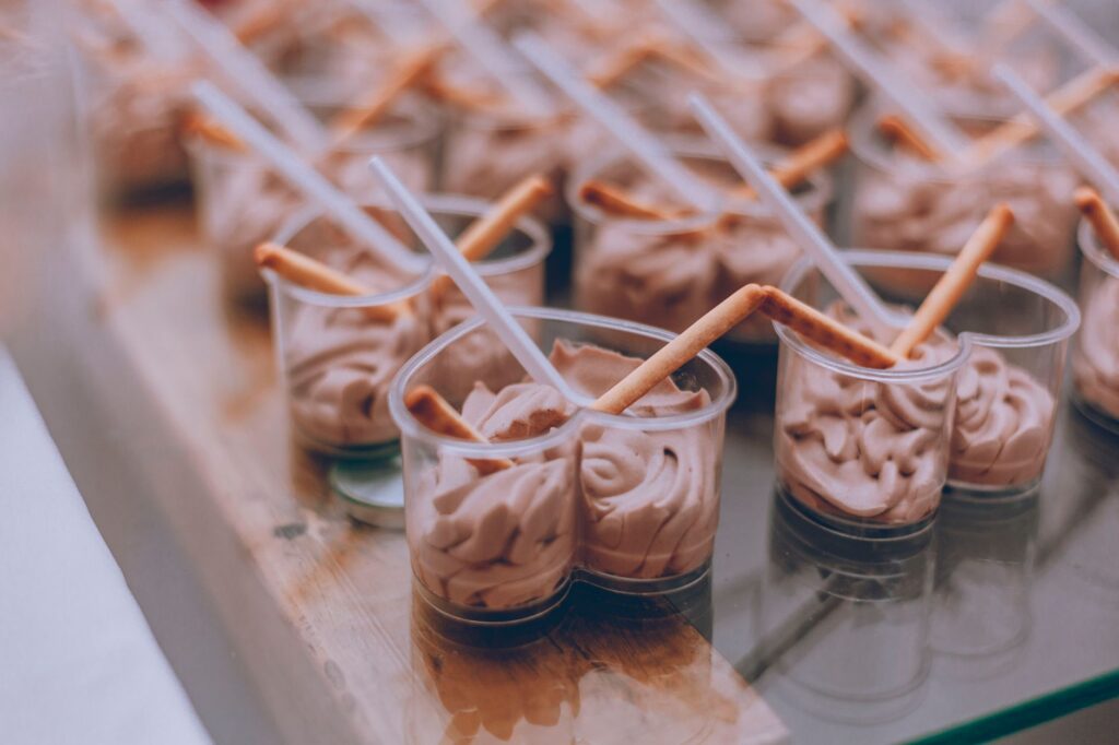 Mousse au chocolat crémeuse dans des tasses transparentes avec des bâtonnets de pain, parfaite pour les amateurs de desserts.