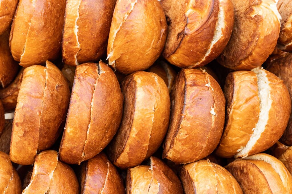 Gros plan de pains à hamburger dorés et bien empilés, mettant en valeur leur texture délicieuse.