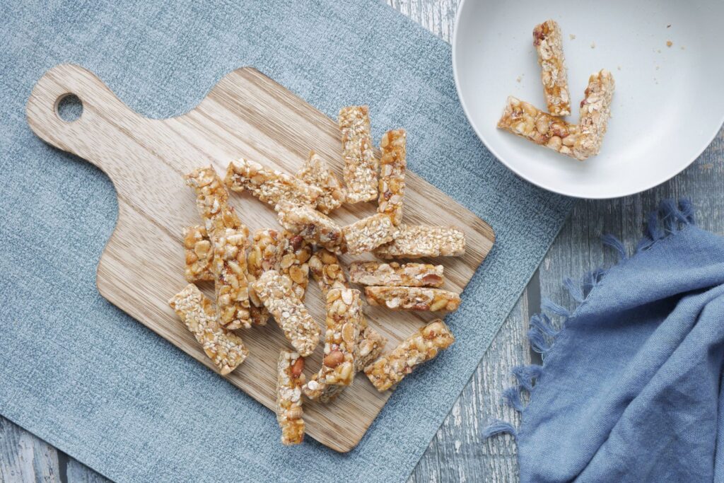 Vue du dessus de barres de granola maison sur une planche à découper en bois, mettant en avant des en-cas sains.