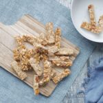 Vue du dessus de barres de granola maison sur une planche à découper en bois, mettant en avant des en-cas sains.