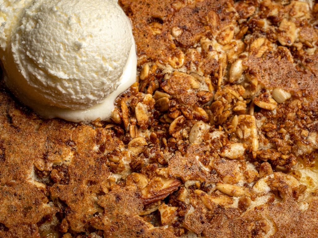 Gros plan sur un gâteau aux amandes croquant garni de crème glacée à la vanille.