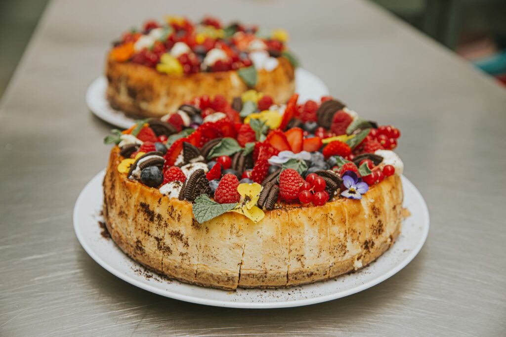 Un cheesecake délicieux surmonté de baies fraîches et de biscuits, parfait pour les amateurs de desserts.
