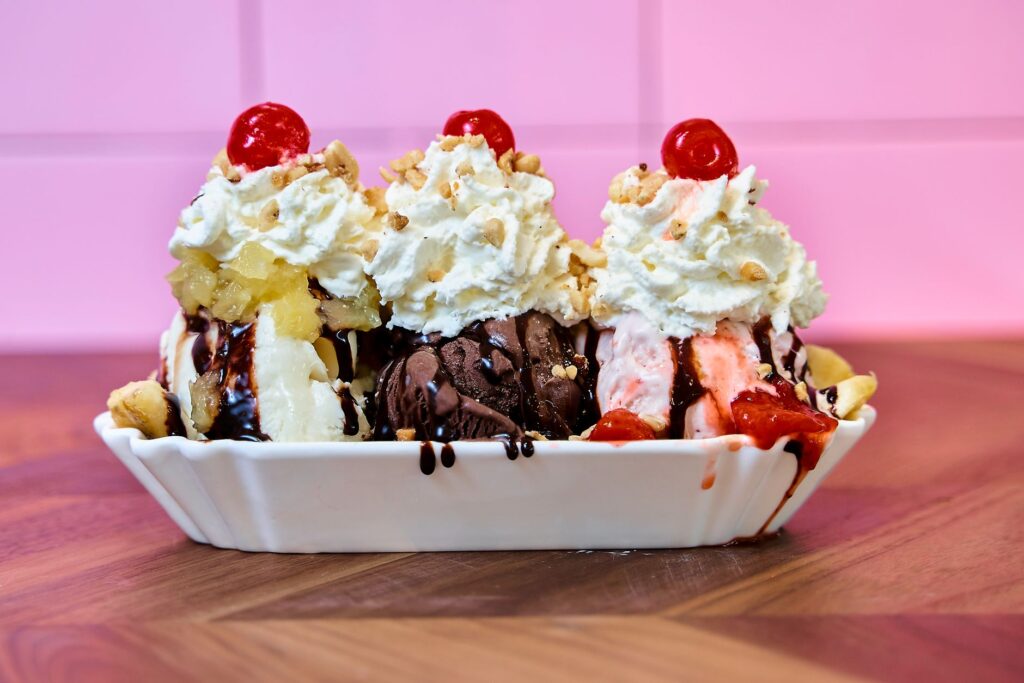 Savourez un classique banana split garni de cerises, de crème fouettée et de sauce au chocolat.