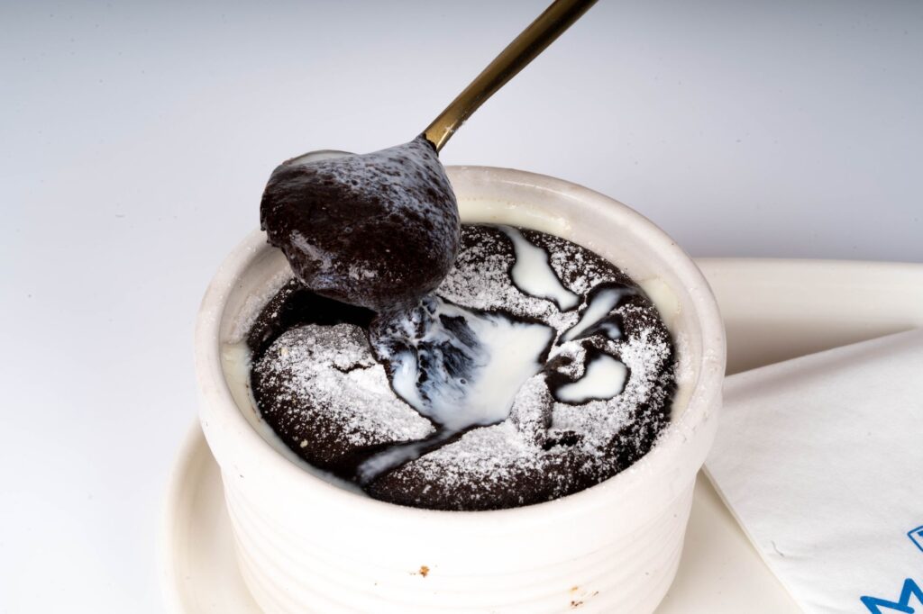 Savourez un riche gâteau au chocolat coulant servi dans une tasse en céramique blanche.