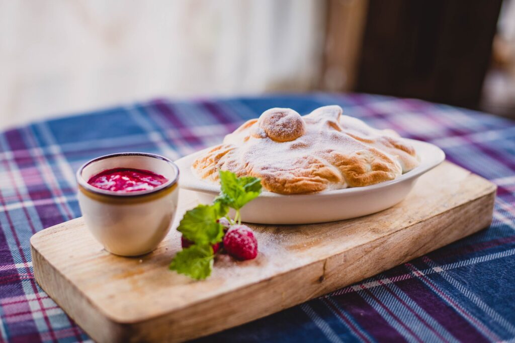Délicieux dessert cuit avec sauce aux baies et menthe sur planche en bois.