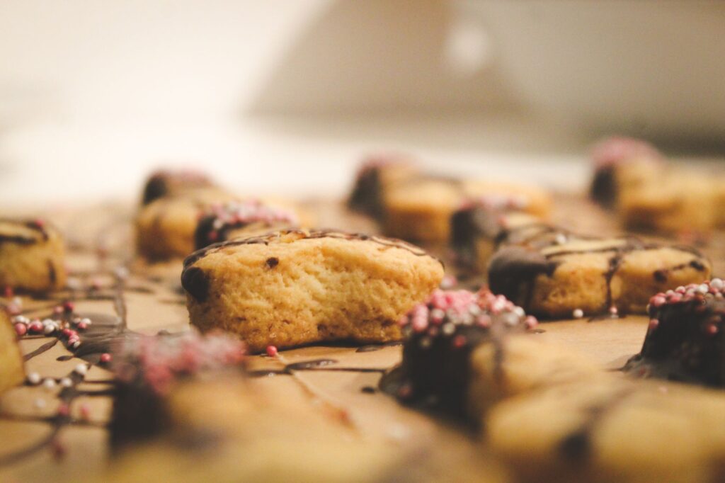 De délicieux cookies nappés de chocolat et parsemés de billes colorées, capturés en gros plan.