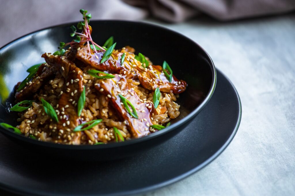 Délicieux bœuf teriyaki avec du riz garni de graines de sésame et d'oignons verts.