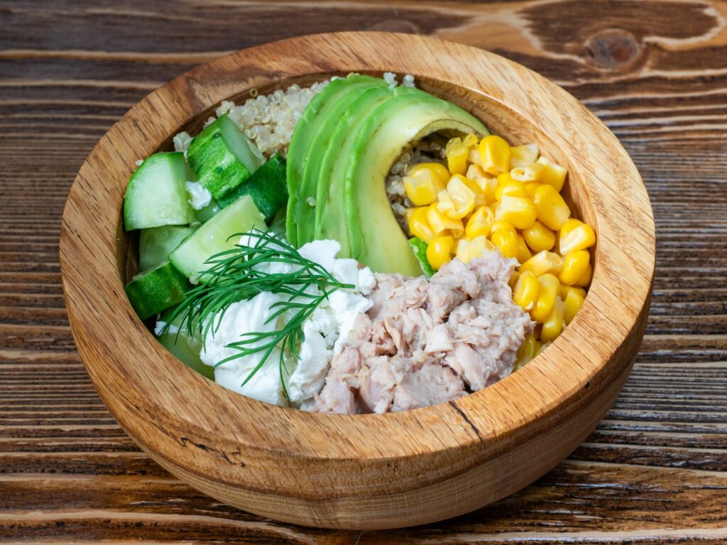 Un bol de salade fraîche avec du thon, de l'avocat, du quinoa et des légumes. Parfait pour un repas sain.