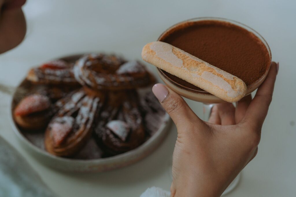 Gros plan sur un tiramisu avec biscuit à la cuillère et churros, idéal pour les menus de dessert.