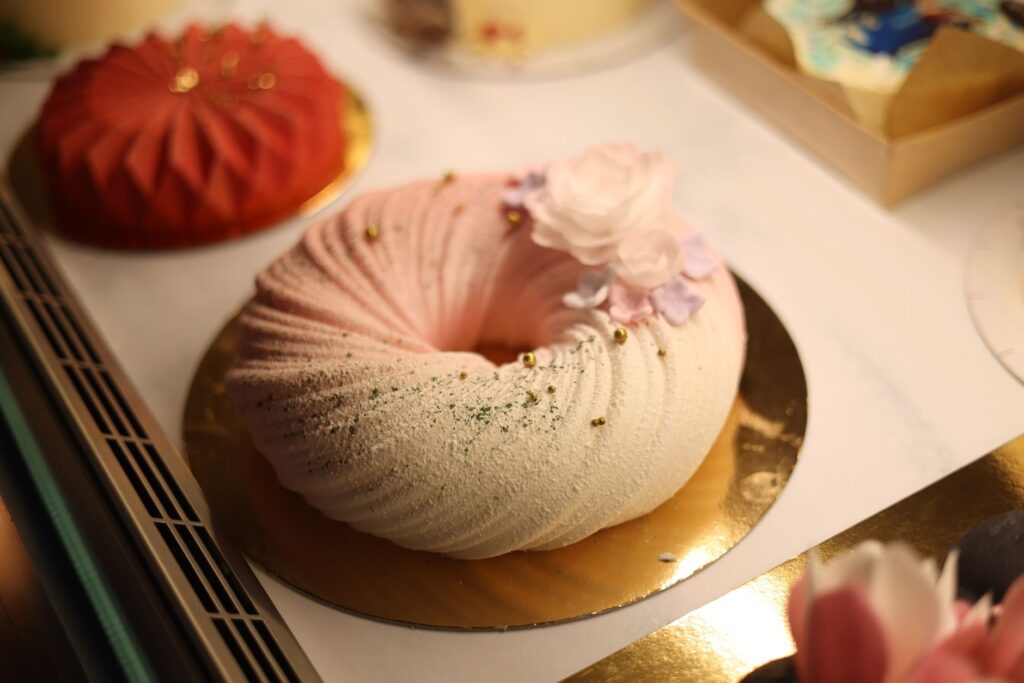 Gros plan d'un dessert joliment décoré avec des éléments floraux pastel, parfait pour les occasions festives.