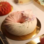 Gros plan d'un dessert joliment décoré avec des éléments floraux pastel, parfait pour les occasions festives.