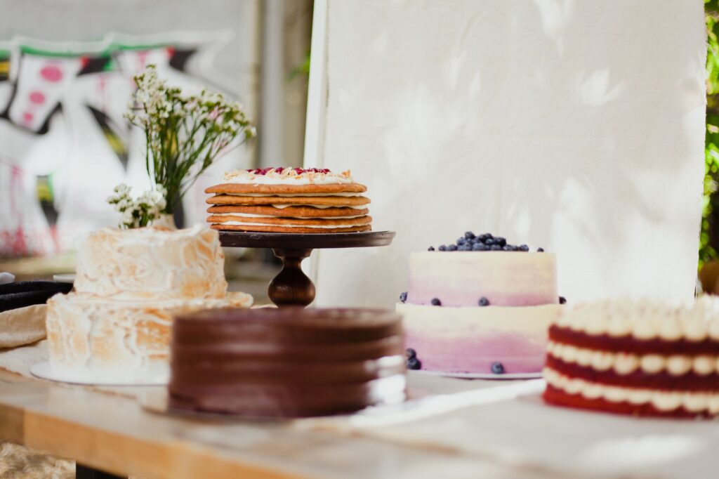 Une variété de gâteaux magnifiquement décorés sur des supports, parfaits pour les amateurs de desserts.