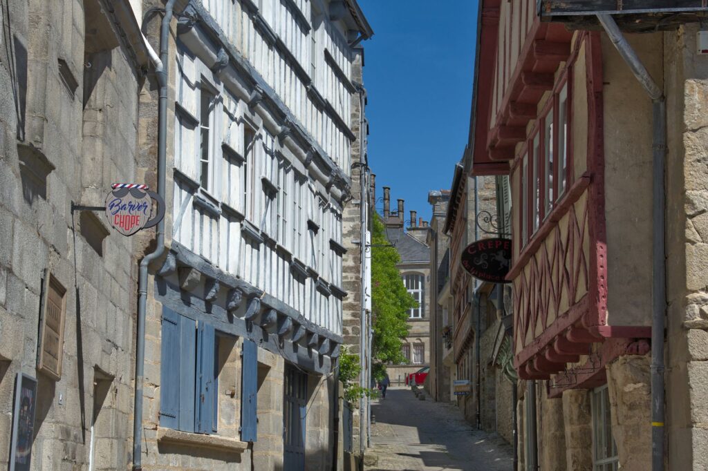 Charmante rue historique à Quimper, mettant en valeur l'architecture traditionnelle bretonne sous un ciel bleu dégagé.