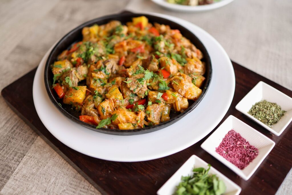 Un gros plan d'un plat de poêlée coloré de légumes mélangés et de viande garni d'herbes.