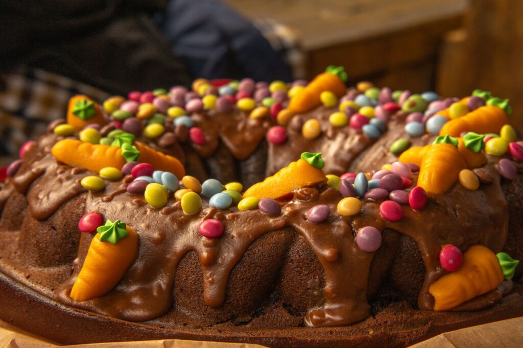 Gros plan sur un gâteau Bundt au chocolat décoré de bonbons colorés et de glaçage, parfait pour les célébrations festives.