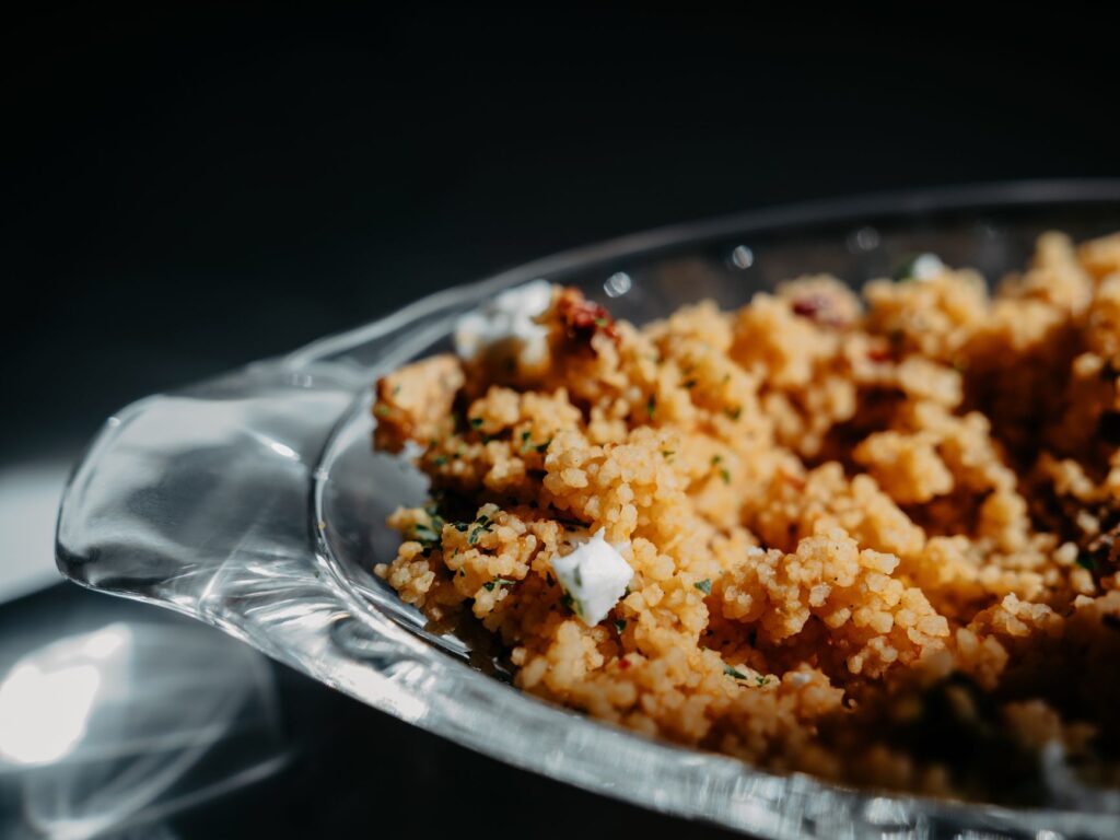 Gros plan sur du couscous fait maison servi dans un plat en verre, parfait pour le dîner.