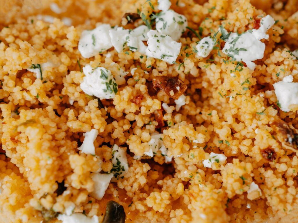 Délicieuse salade de couscous garnie de fromage et d'herbes. Un plat fait maison parfait avec des ingrédients frais.