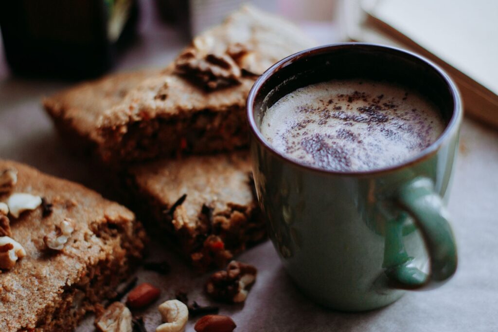 Délicieux café chaud servi avec des tranches de gâteau aux carottes et aux noix, parfait pour une douceur confortable.