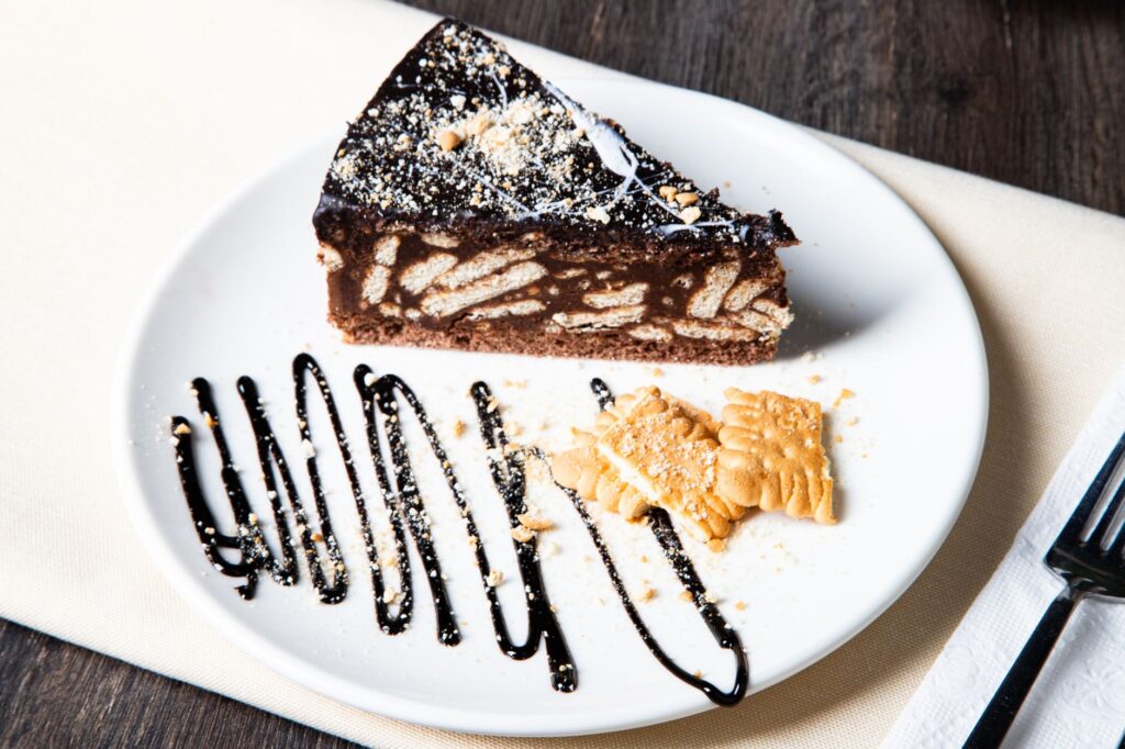 Savourez un gros plan d'une tranche de gâteau au biscuit au chocolat avec une garniture élégante sur une assiette.
