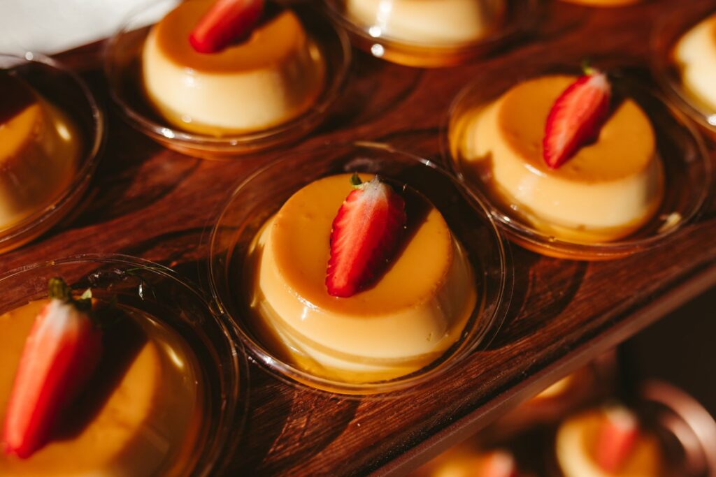Desserts flan séduisants garnis de fraises joliment présentés sur une planche en bois.