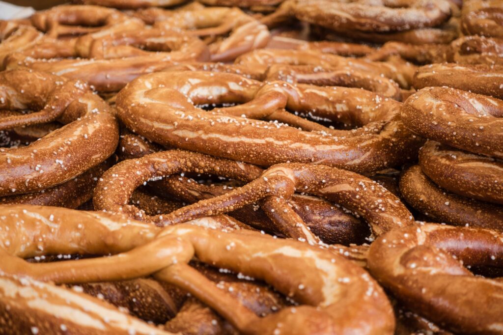 Gros plan sur une pile de pretzels fraîchement cuits avec du sel, mettant en valeur la texture et la couleur.