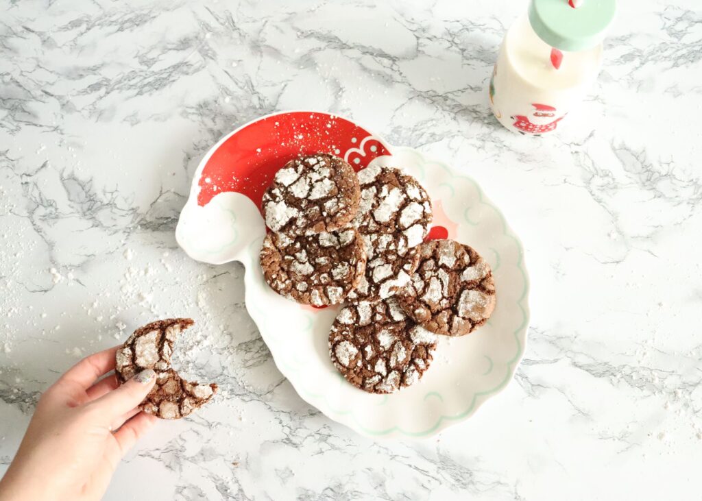 Délicieux biscuits faits maison en forme de crinkle présentés sur une assiette en forme de Père Noël avec une bouteille de lait.
