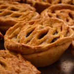 Tartes aux pommes dorées avec des croûtes en treillis, capturant l'essence des délices traditionnels de la boulangerie mexicaine.