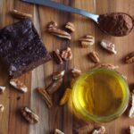 Vue à plat d'un brownie au chocolat fait maison avec des pacanes, du cacao et de l'huile. Parfait pour des visuels de pâtisserie.