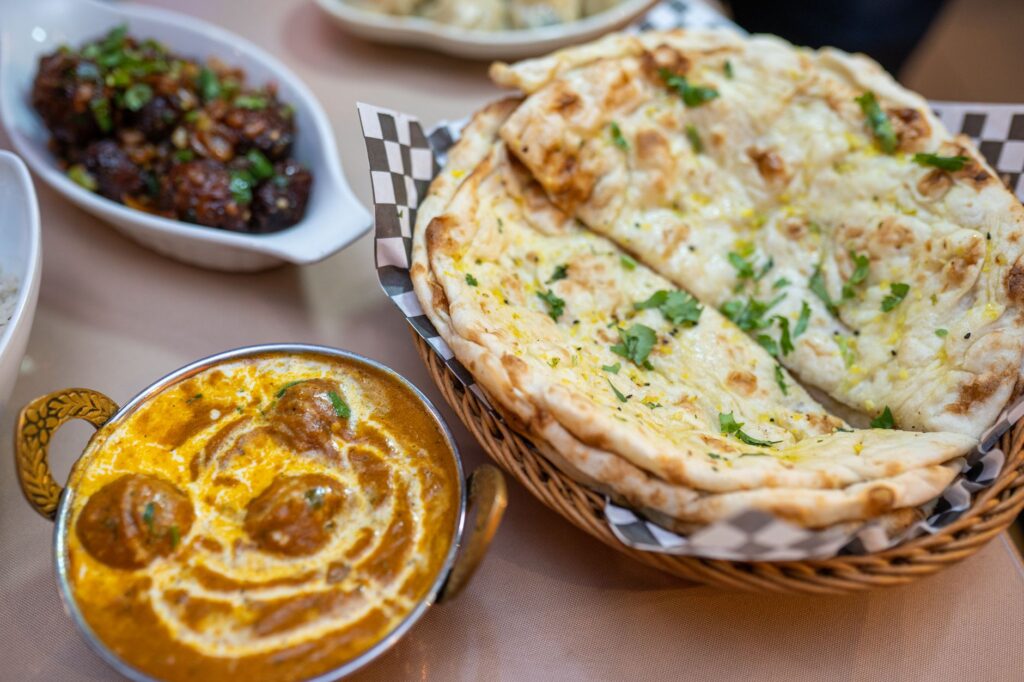 Une délicieuse sélection de la cuisine indienne avec du curry, du pain naan et des plats savoureux.