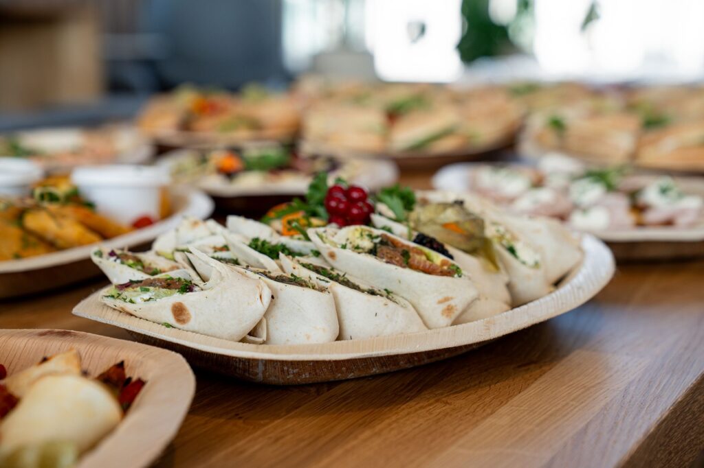 Un plateau en bois de wraps végétariens assortis avec des ingrédients frais, parfait pour les fêtes.