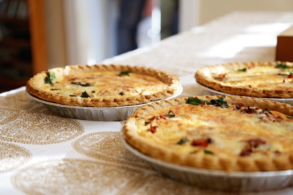 Délicieuses quiches maison sur une nappe à motifs classiques, accueillantes et savoureuses.