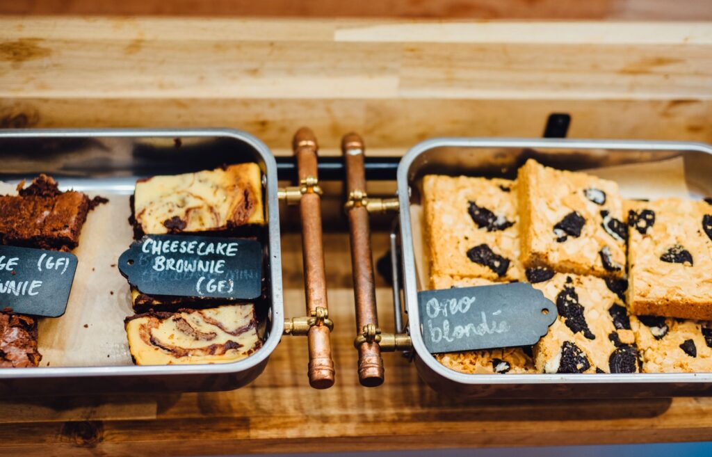 Une présentation alléchante de brownies et de blondies sans gluten dans des plateaux, parfaits pour les amateurs de desserts.