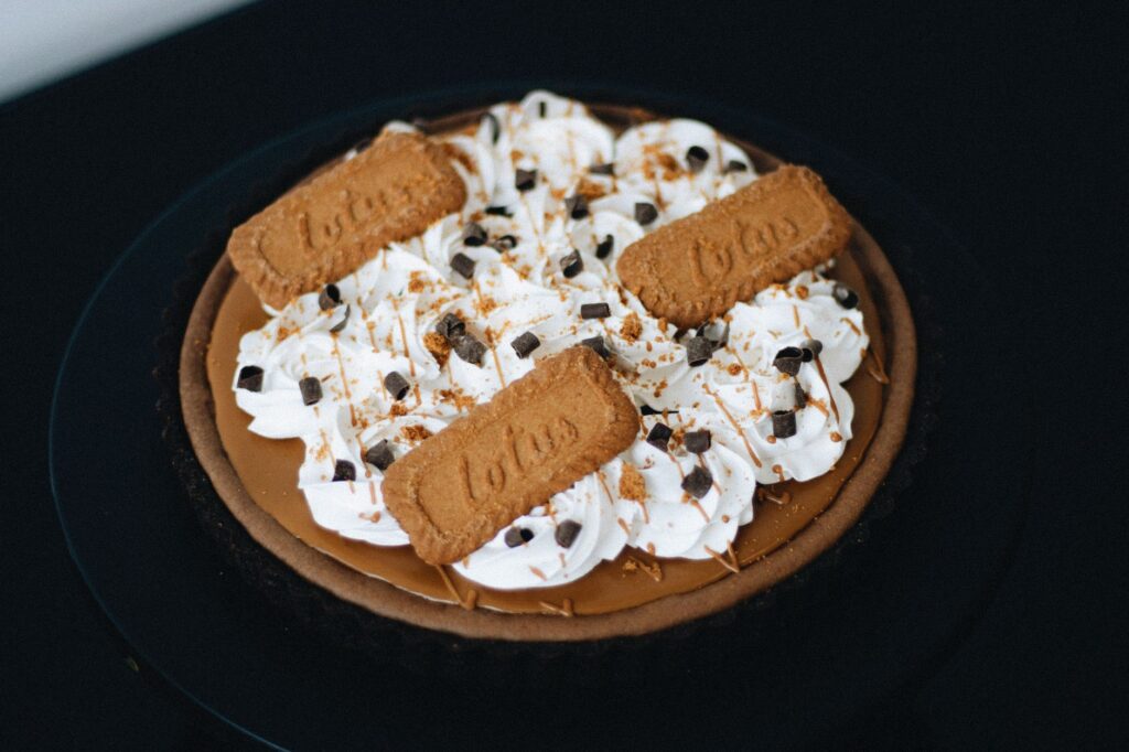 Une délicieuse tarte à la crème de biscuits spéculoos avec garniture fouettée, parfaite pour les amateurs de desserts.