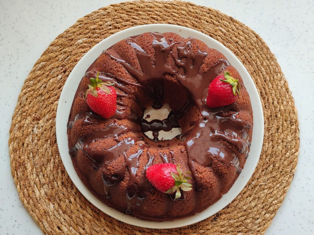 Offrez-vous ce riche gâteau bundt au chocolat surmonté de fraises fraîches, parfait pour les amateurs de desserts.