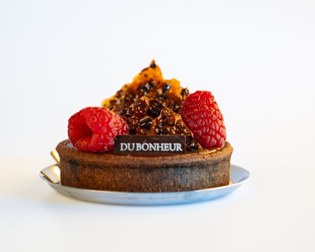 Gros plan d'une délicieuse tarte aux framboises avec garniture caramélisée de Du Bonheur.