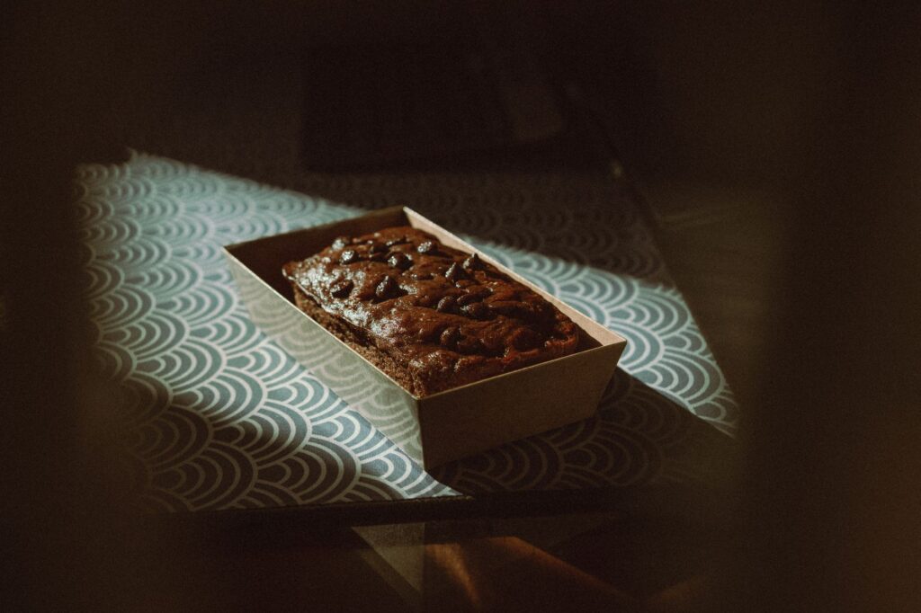 Un riche gâteau au chocolat avec une ambiance vintage, placé sur une table à motifs dans une lumière douce.