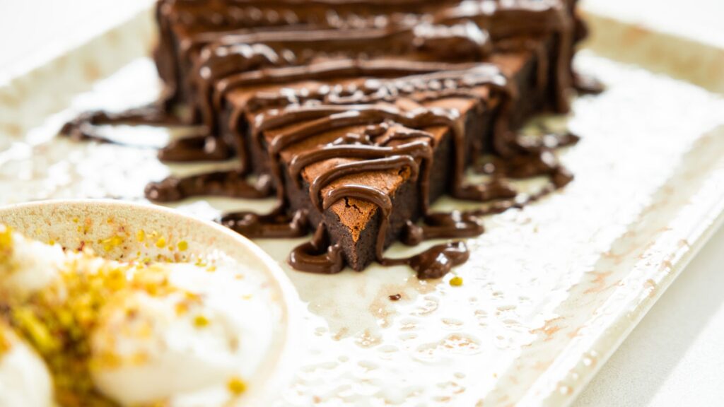 Gros plan sur un brownie au chocolat gourmand, arrosé d'une riche sauce au chocolat. Idéal pour les gourmands.